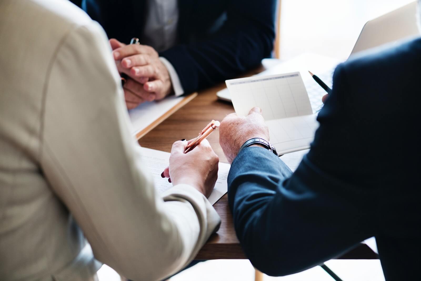 It looks like this image shows a business meeting or consultation, with people reviewing documents at a table.