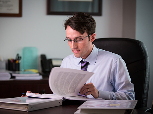 A lawyer sitting at a desk looking at paperwork