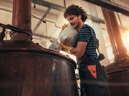 A man pouring a bag into a distillerie