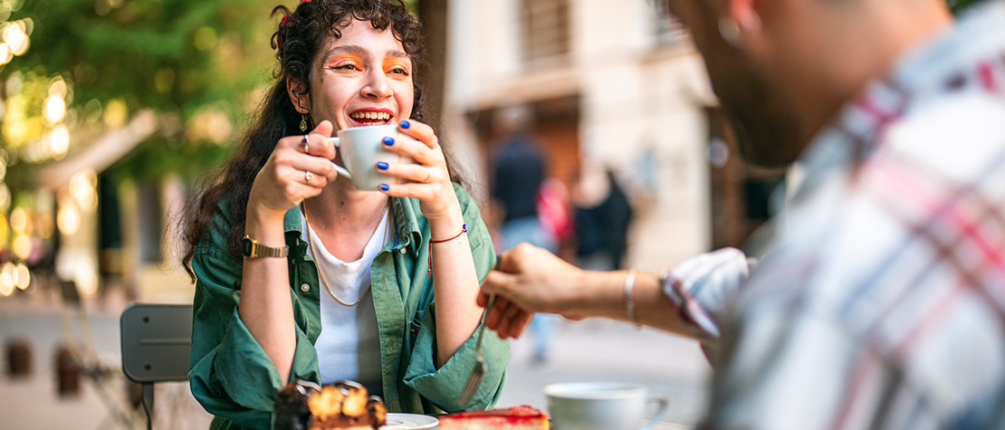 A woman sitting at a table at an outdoor restaurant with a. man